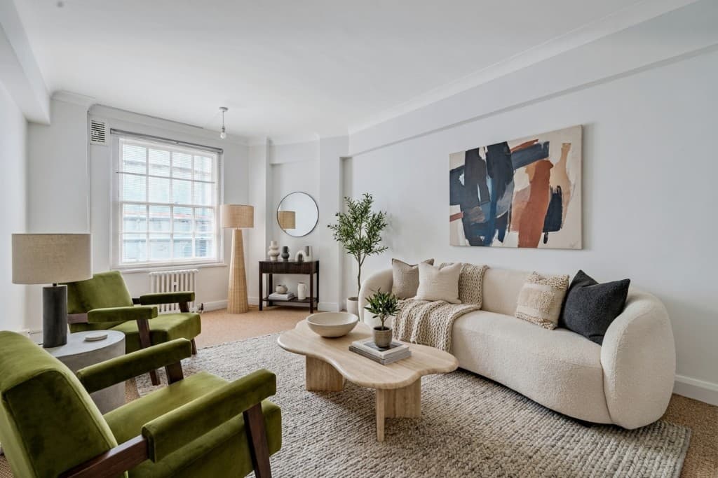 The same room virtually staged in a contemporary style with sofa, armchairs and modern lighting