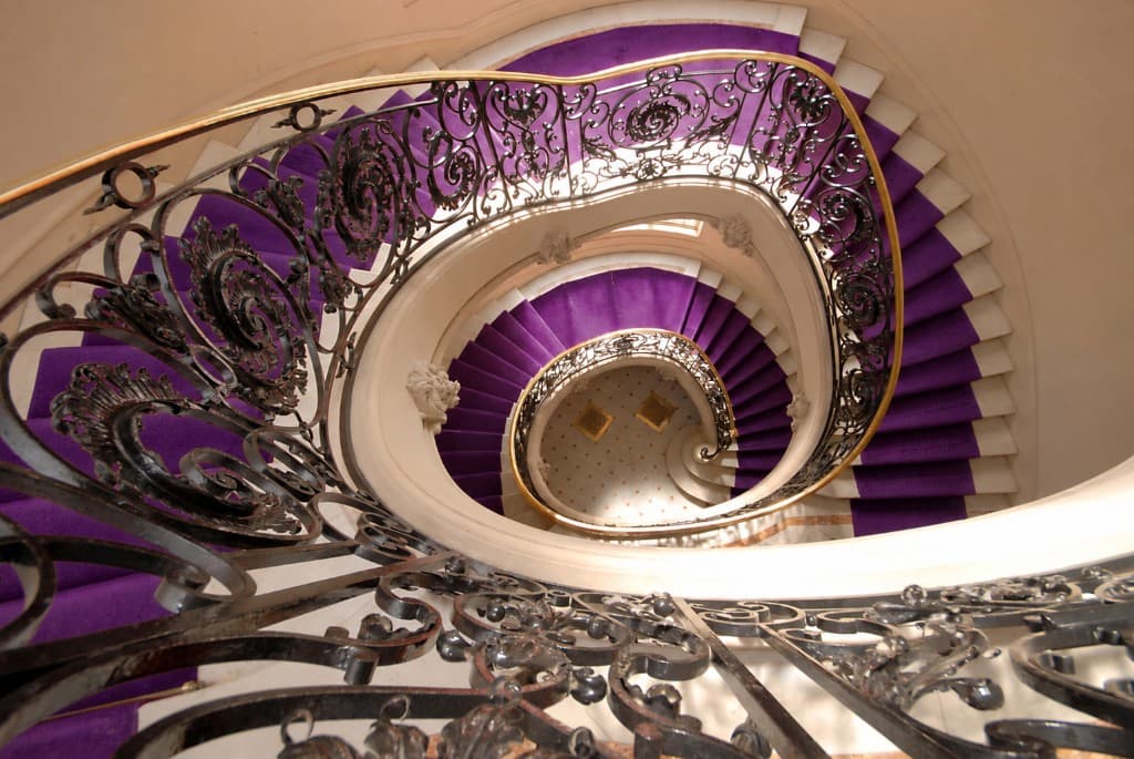 Ornate spiral staircase with the carpet runner changed to purple